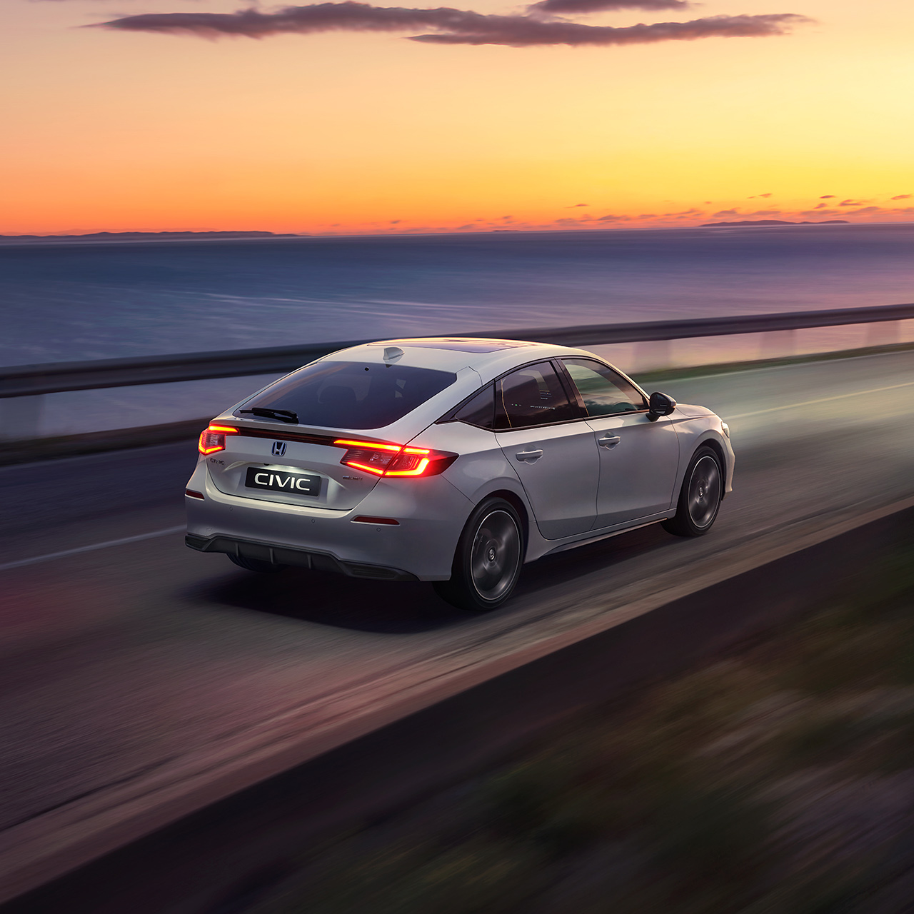 Civic Hybrid car driving in the sunset.