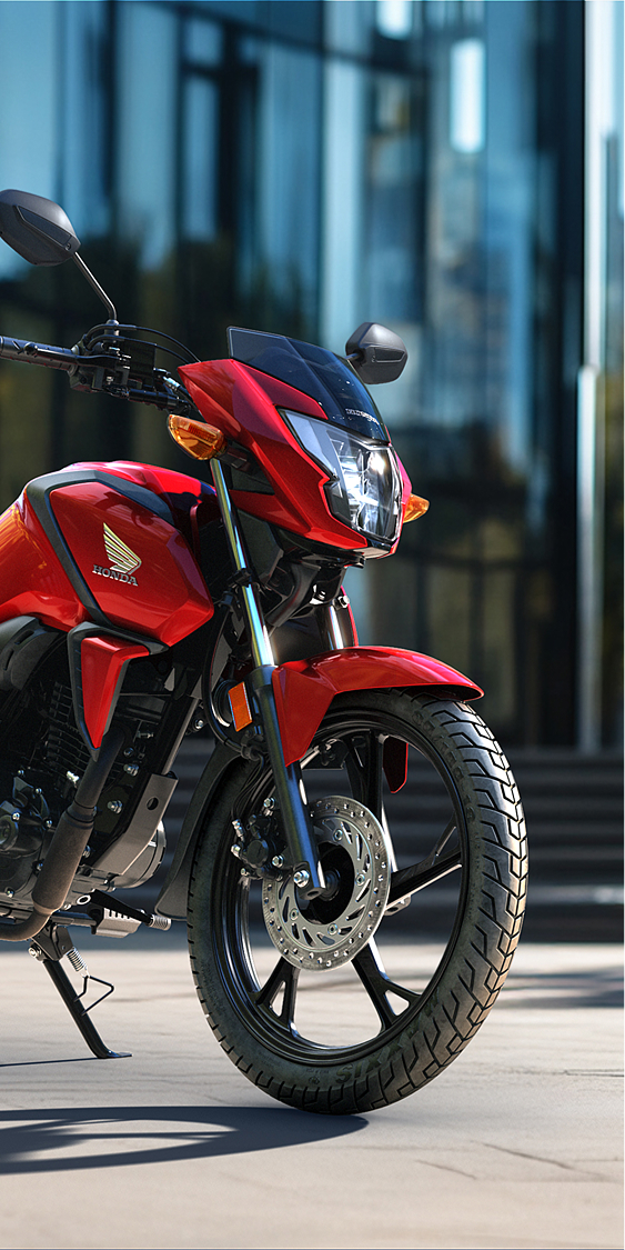 Trojštvrťový pohľad spredu z ľavej strany na červený stroj CB125F na mestskej ceste