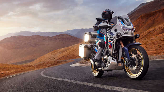 Dynamický záber zboku na motocykel Africa Twin Adventure Sports s jazdcom