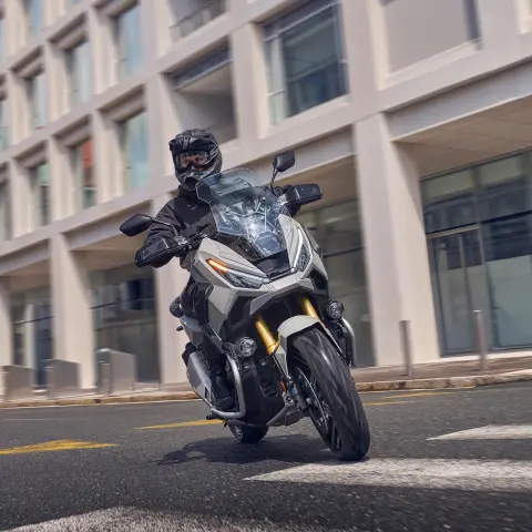 Jazdec na skútri Honda X-ADV na mestských cestách.