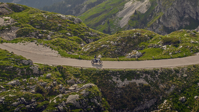 Jazdec jazdiaci na motocykli XL750 Transalp na ceste v horskom prostredí.