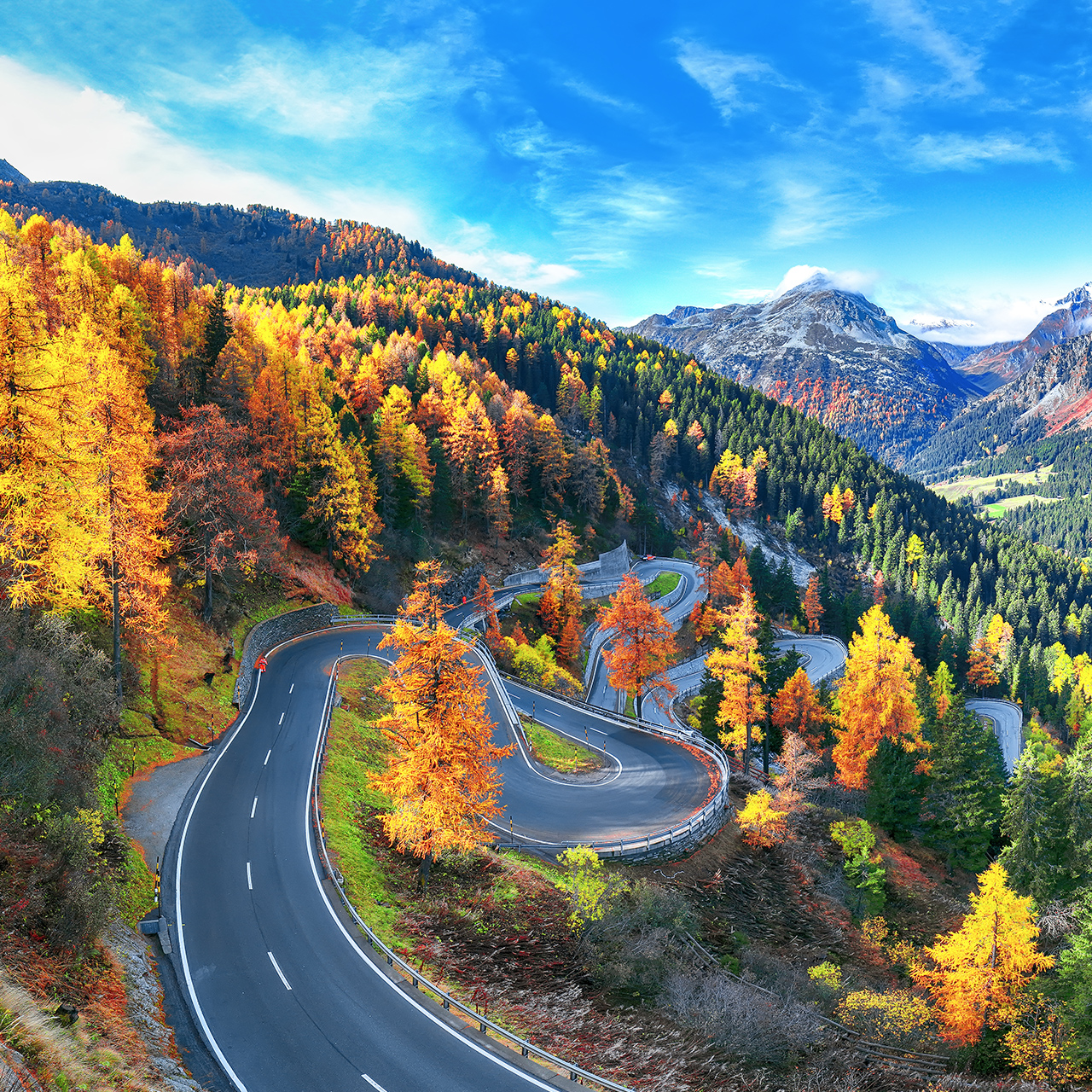 Úžasný pohľad na cestu v priesmyku Maloja v jesennom období. Farebná jesenná scenéria švajčiarskych Álp. Miesto: Priesmyk Maloya, región Engadine, kantón Grisons, Švajčiarsko, Európa