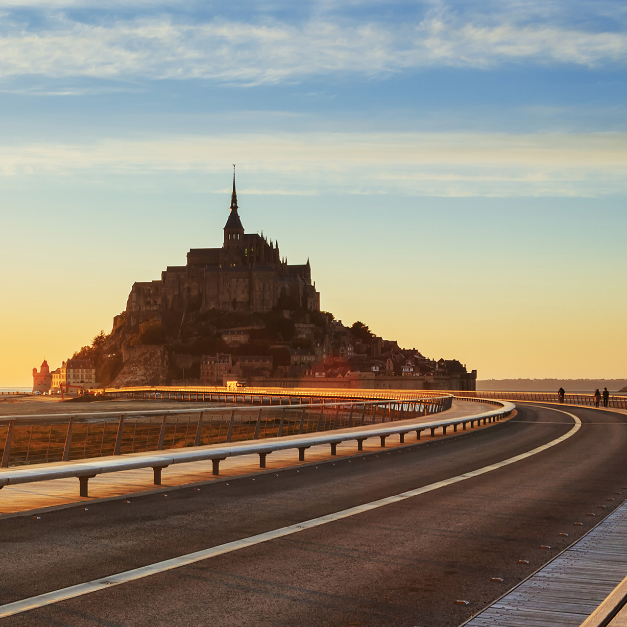 Cesta na Mont-Saint-Michel pri západe slnka, Normandia, Francúzsko.