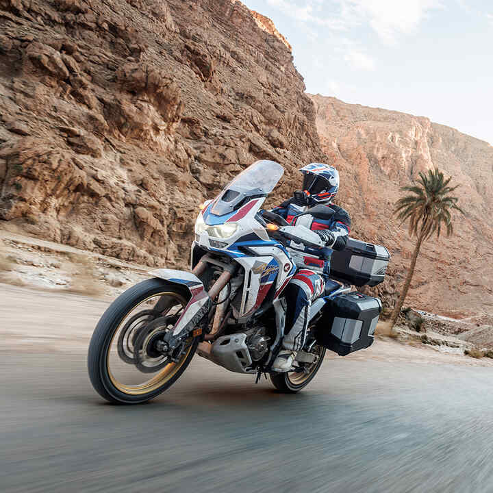 Model Africa Twin v teréne so súpravou príslušenstva Touring s jazdcom.