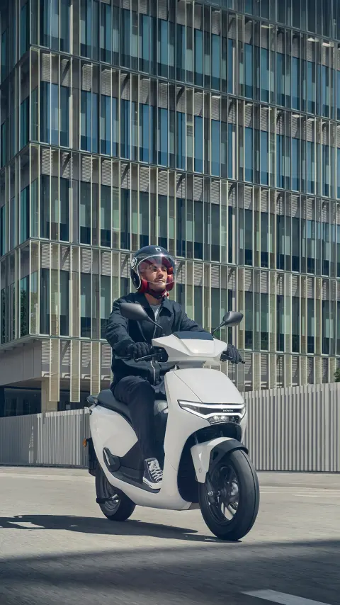 Figurant pri jazde na motocykli Honda CUV e: na ulici.