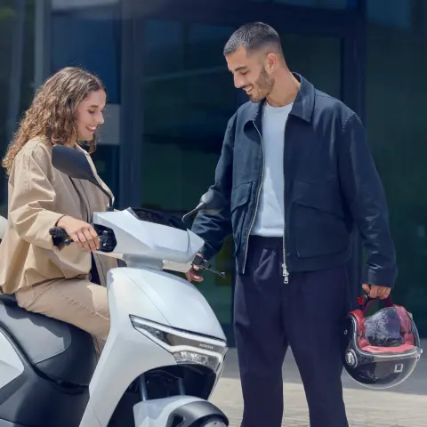 Figuranti sledujúci skúter Honda CUV e: v meste