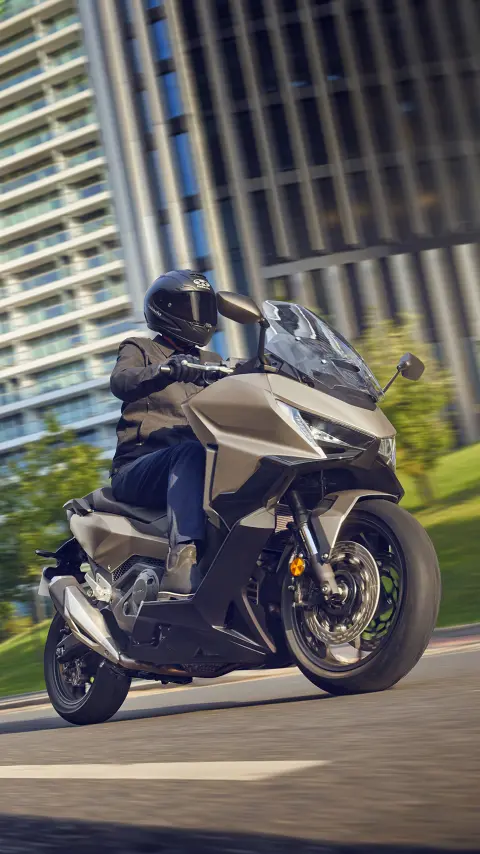 Jazdec na motocykli Forza 750 pri jazde v meste.