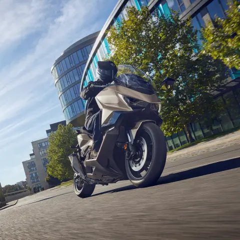 Figurant na motocykli Forza 750 pri jazde po ulici.