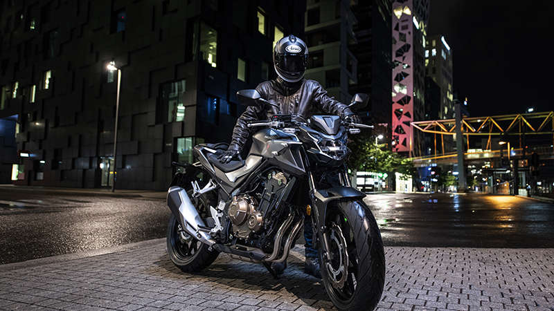 CB500F, trojštvrťový predný pohľad z pravej strany na stroj s jazdcom v nočnom meste