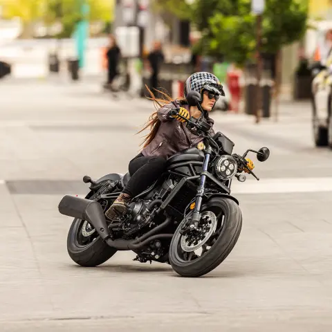 Záber spredu na figuranta na motocykli Honde CMX1100 v meste.