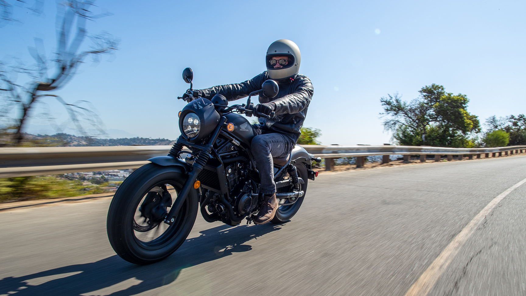 Jazdec na stroji Honda CMX500 Rebel na ceste.