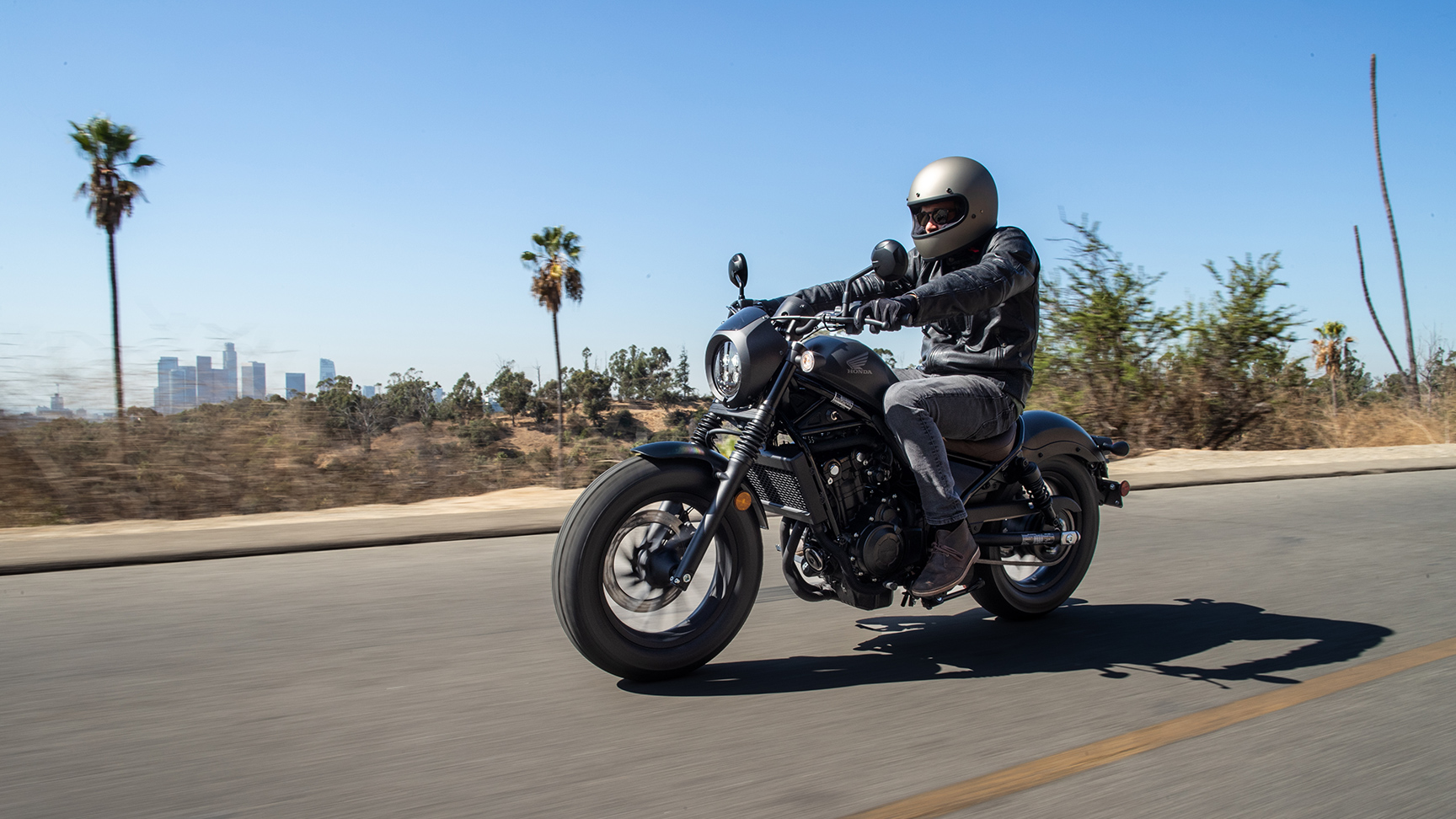 Honda CMX500 Rebel s jazdcom pri jazde po ceste. 