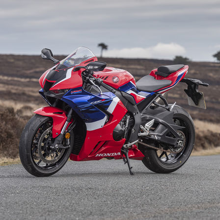 Honda CBR1000RR-R Fireblade, trojštvrťový záber spredu z pravej strany na červený motocykel zaparkovaný na ceste