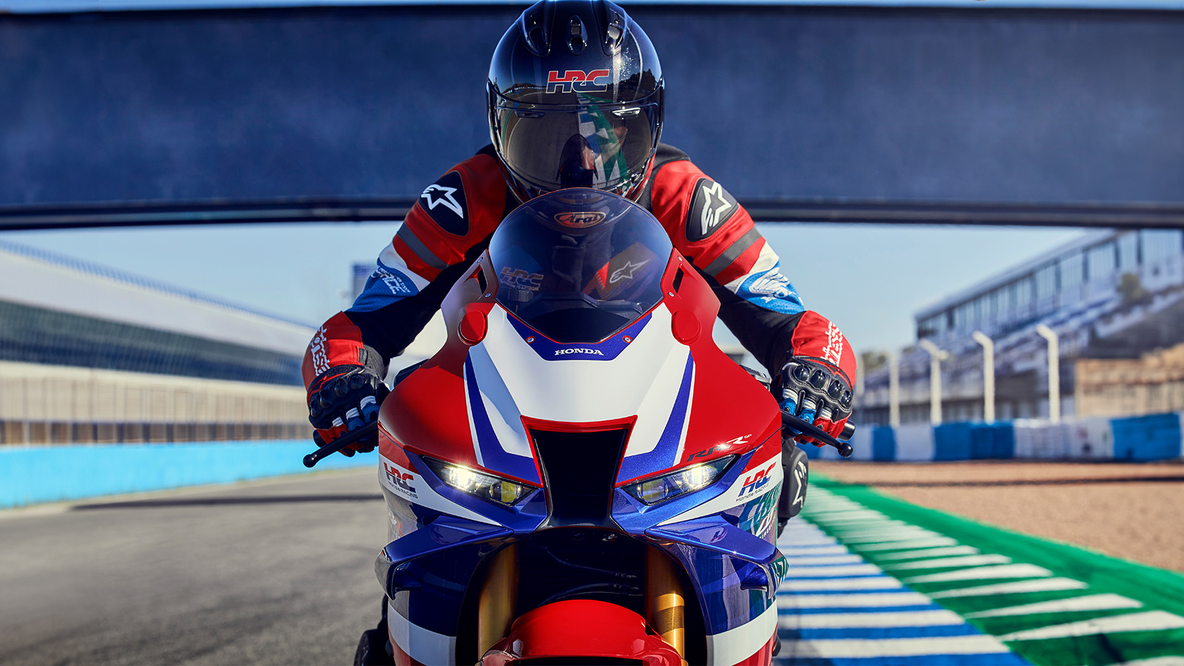 Detailný pohľad spredu na jazdca na modeli Honda CBR1000RR-R Fireblade na pretekárskej trati. 
