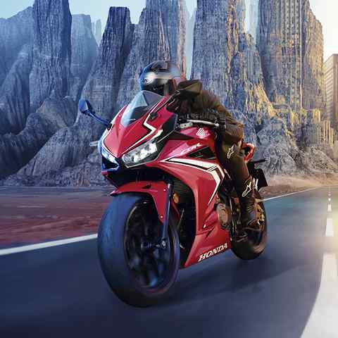 CBR500R, trojštvrťový pohľad spredu z ľavej strany na jazdca jazdiaceho po ceste