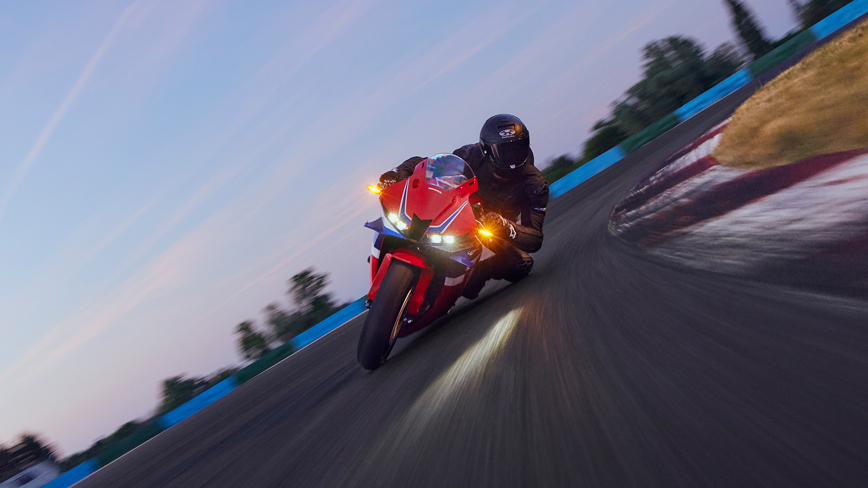 CBR600RR na okruhu s jazdcom v zákrute.