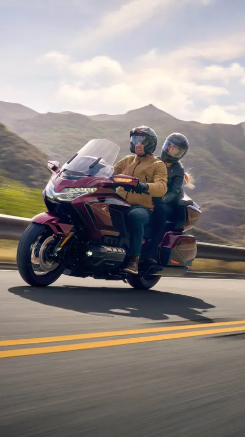 Dvaja ľudia na motocykli Honda GL1800 Gold Wing Tour, hory v pozadí.